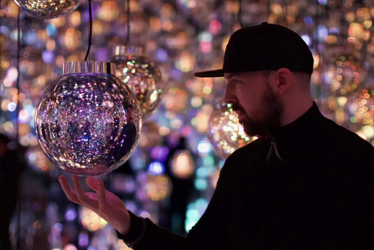 Holding a light orb art installation