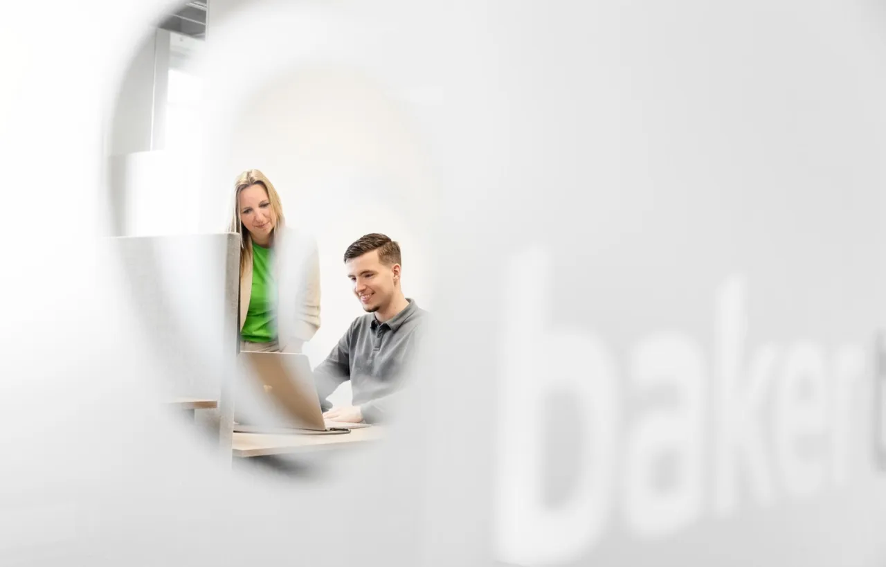 Two employees behind a laptop